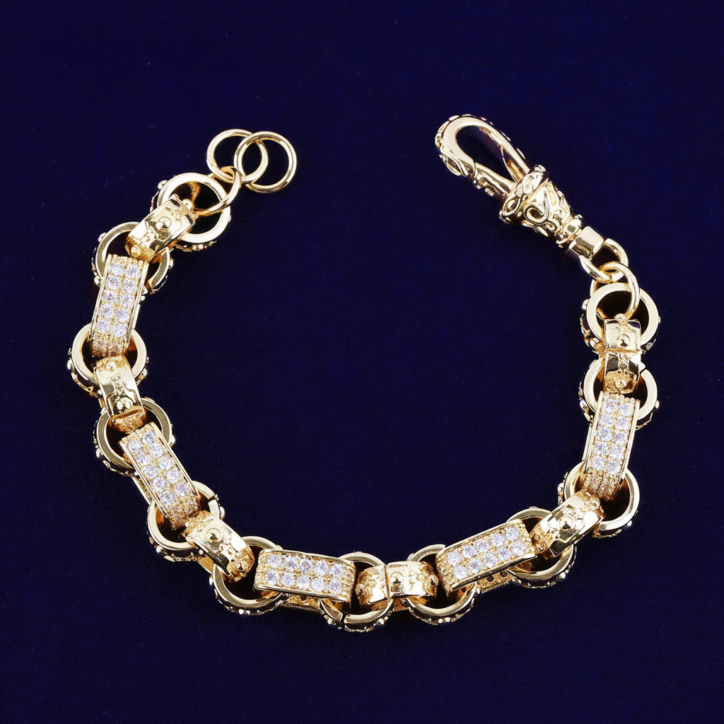 A gold-tone  Gypsy Link Bracelet chain bracelet with rectangular links paved with clear rhinestones, displayed on a dark blue background .