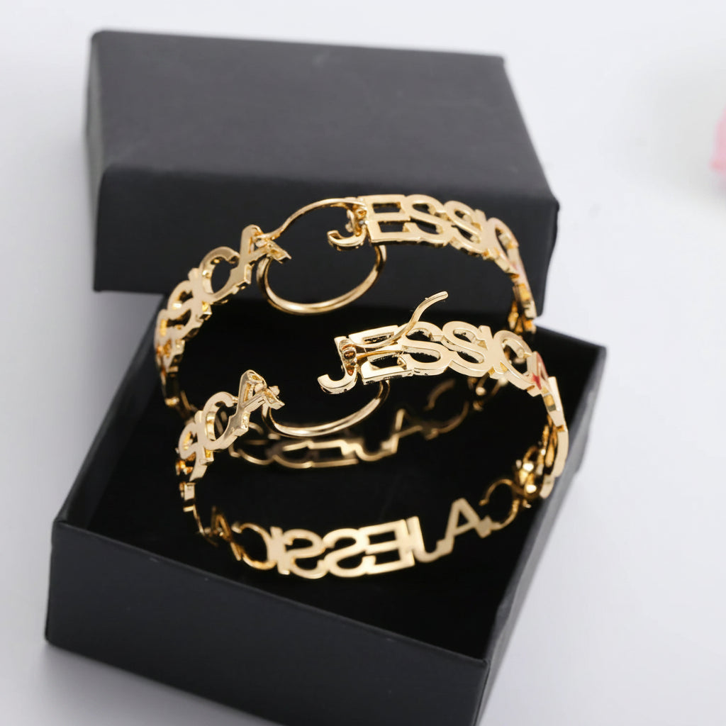 Gold bracelet with 'JESSICA' engraving on a black box, brand 'Qitian Jewelry' visible.